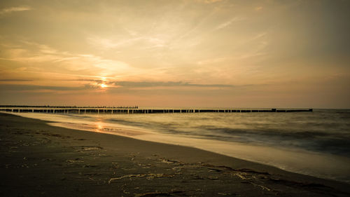 Scenic view of beach against sky during sunset