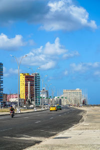 Road by city against sky