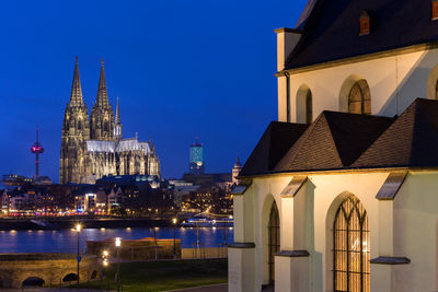 Illuminated buildings in city against sky