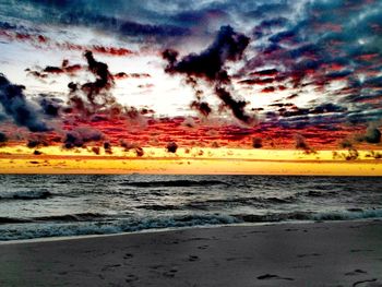 Scenic view of sea against dramatic sky during sunset