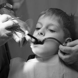 Close-up of dentist examining teeth of boy at clinic