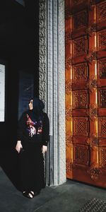 Woman standing by window in building