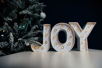 Close-up of christmas decoration on table against black background