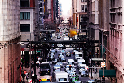 Traffic on road amidst buildings in city