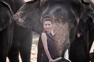 Woman looking away near elephant