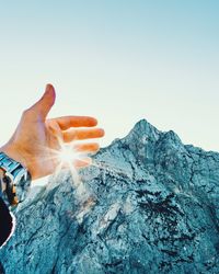 Cropped image of hand against sky