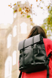 Rear view of woman backpack standing against castle 