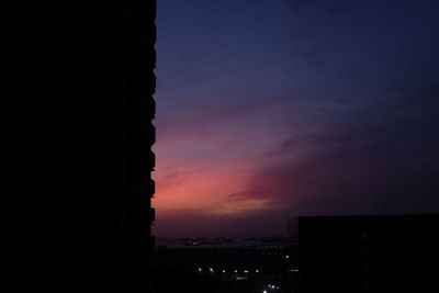 Silhouette buildings against sky at sunset