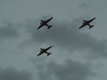 Low angle view of silhouette airplane flying in sky