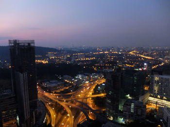 High angle view of illuminated cityscape against sky at night