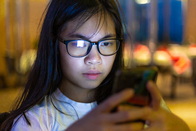 Close-up portrait of woman with mobile phone