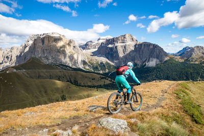 Rear view of woman riding bicycle on mountain