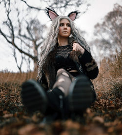 Young woman standing against tree during autumn