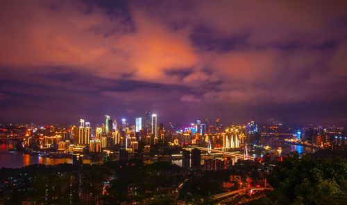 Illuminated cityscape against sky at night