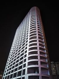 Low angle view of modern building against sky at night