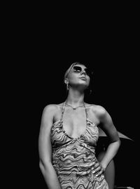 Young woman looking up against black background