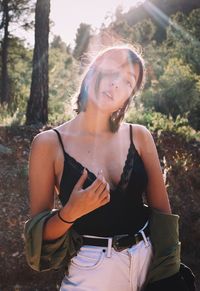 Portrait of woman standing against trees