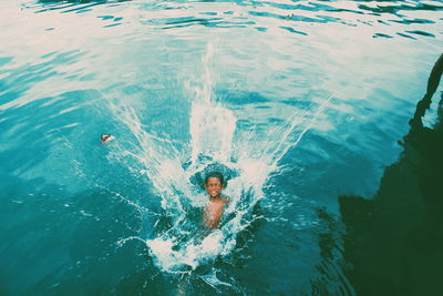 High angle view of boy splashing water in lake