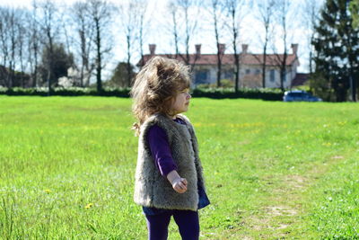 Side view of girl standing on field