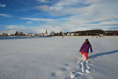 Rear view of man on snow against sky