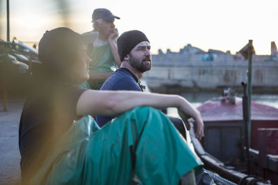 Fishermen sitting in harbour at sunset