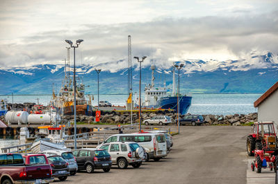 Seafront views at husavik port. there are parking lots and two large boats 