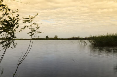 Scenic view of lake against sky at sunset