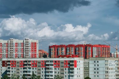 Low angle view of buildings against cloudy sky