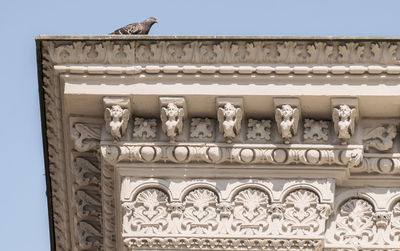 Low angle view of sculptures on building against sky