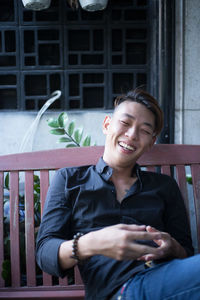 Smiling young man sitting outdoors