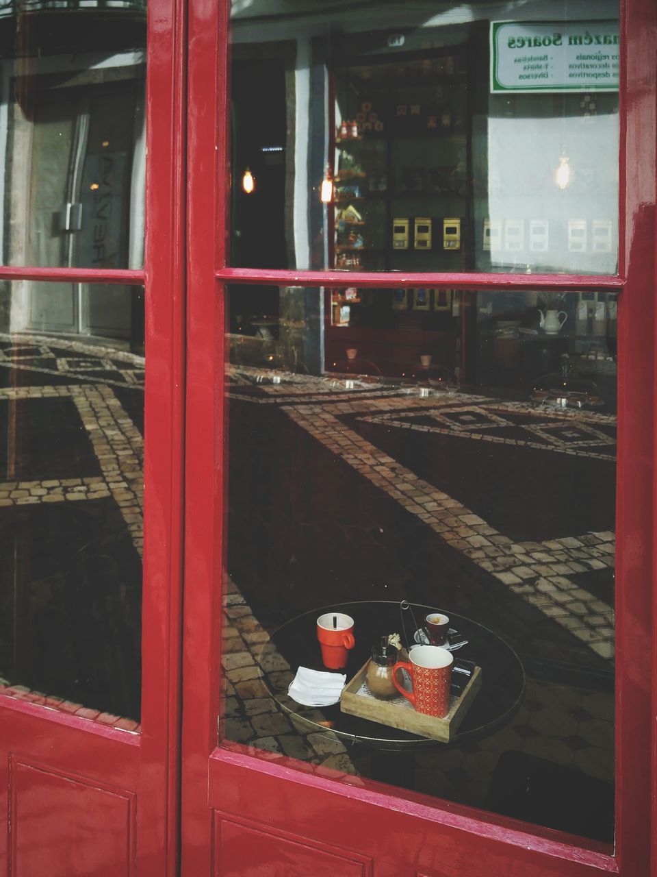 REFLECTION OF RED WINE IN GLASS WINDOW ON MIRROR