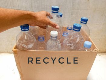 Cropped image of man holding plastic bottles