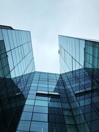 Low angle view of modern glass building against sky