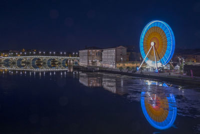 Illuminated ferris wheel at night