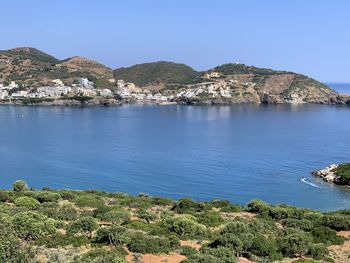 Scenic view of sea and mountains against clear blue sky