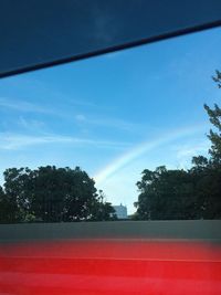 Scenic view of rainbow over trees against sky