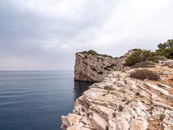 Rock formation on sea against sky