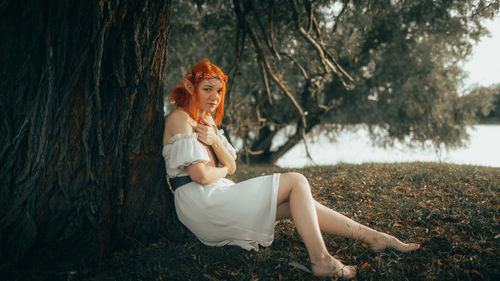 Side view of woman sitting on rock