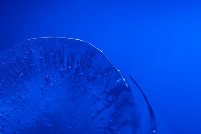 Close-up of glass against blue background