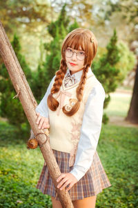 Portrait of smiling young woman standing in park