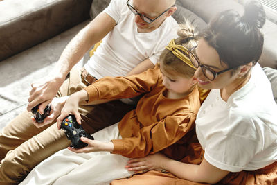 High angle view of family sitting on sofa at home