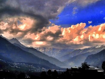 Scenic view of landscape against dramatic sky at sunset