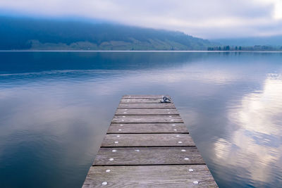 Pier over lake against sky