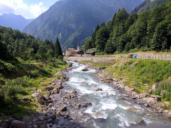 Scenic view of river amidst mountains against sky