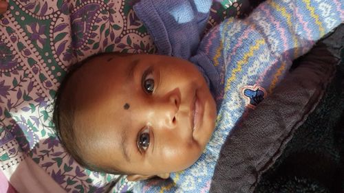 Portrait of cute baby lying on bed