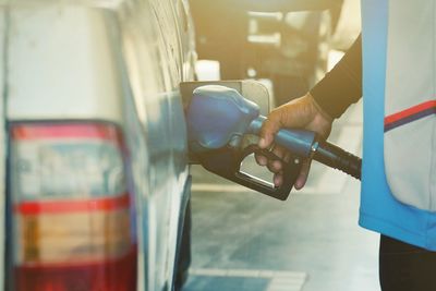 Midsection of man refueling car