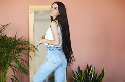 Portrait of woman standing against wall