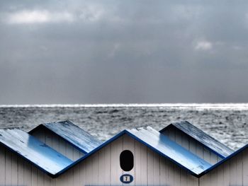 Close-up of wooden table at beach against sky