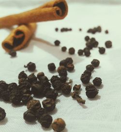 Close-up of cinnamons and black peppercorn on table