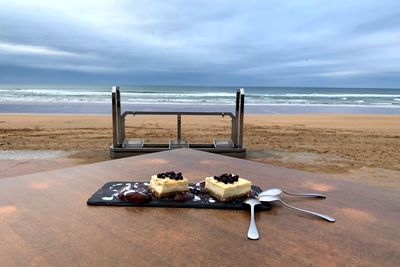 Container on table at beach against sky